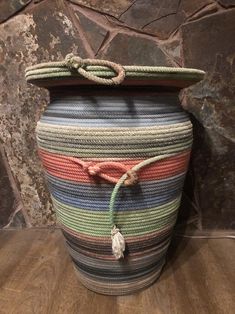 a large multicolored vase with rope on top