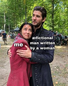 a man and woman hugging each other in front of some trees with words written on them