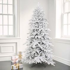 a white christmas tree in a room with presents