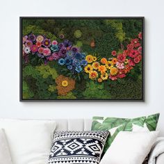 a living room with white couches and colorful flowers on the wall above it is a black framed art print