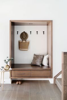 a wooden bench sitting under a wall mounted coat rack