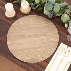 a wooden table with place settings and greenery