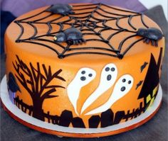 a decorated cake with black icing and spooky spider webs on it