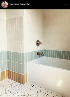 a bath tub sitting under a faucet in a bathroom