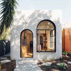 a white house with arched windows and stone walkway