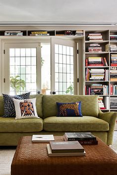 a living room filled with lots of books and furniture