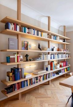 a bookshelf filled with lots of books on top of wooden shelves