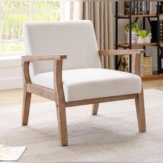 a white chair sitting on top of a rug next to a book shelf filled with books