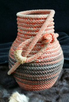 an orange and gray basket sitting on top of a fur rug