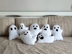 five ghost pillows sitting on top of a bed