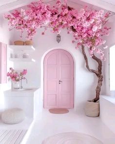 a white bathroom with pink doors and flowers on the tree in the window sill