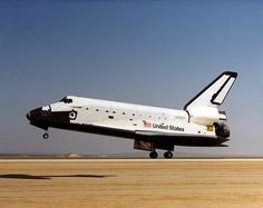 the space shuttle is taking off from an airport runway with it's landing gear down