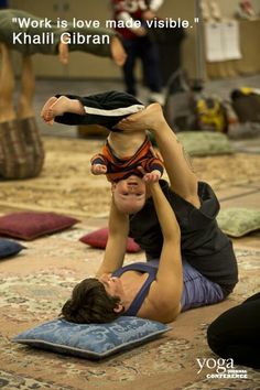 two people doing yoga on the floor with their hands in the air and one person upside down