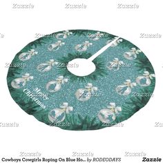 a green and white christmas tree skirt with angels on the front, surrounded by holly leaves