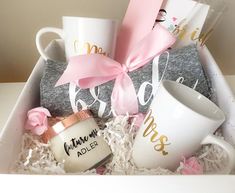 a gift box with coffee mugs, socks and a pink bow on the top