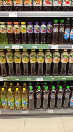 bottles of juice are on display in a grocery store