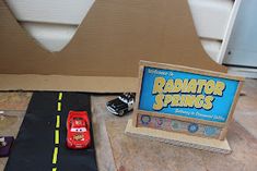 a toy car is sitting on the floor next to a cardboard box that says ramattor springs