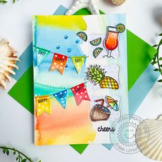 the card is decorated with watercolors and other things on it, along with seashells