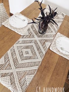 a wooden table topped with white plates and place mats