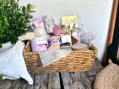 a wicker basket filled with personal care items on a wooden table next to a potted plant