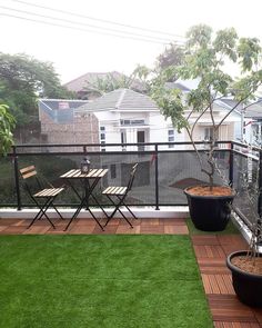 a balcony with grass and potted plants on it