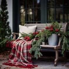 a bench covered in christmas greenery next to a tree