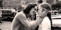 two people standing next to each other on a street