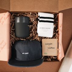 an open box containing a hat, coffee mug and socks