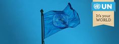 an un flag flying in the wind with a blue sky behind it