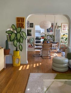 a living room filled with lots of furniture and decor on top of hard wood flooring