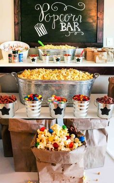 popcorn bar with buckets filled with different types of candies and other snacks on the table