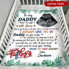 a baby crib with a blanket that says it's my daddy and his name