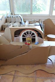 an open cardboard box sitting on top of a floor next to a table and chairs