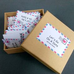 a box filled with lots of envelopes sitting on top of a gray tablecloth