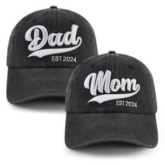 two baseball caps with the words dad and mom on them, one is black and white