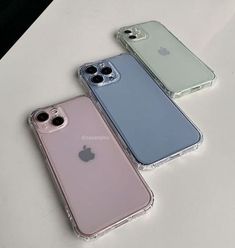 three iphones sitting next to each other on top of a white table with the same color