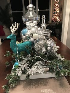 a christmas centerpiece with silver and white ornaments