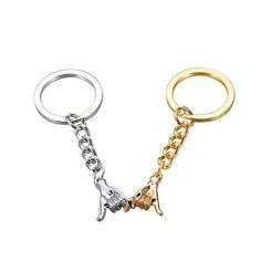 two metal key chains with charms attached to them, one is gold and the other is silver