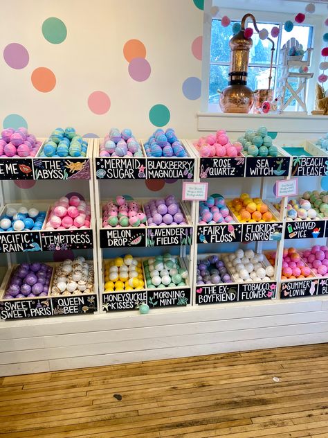 Image is of a wall of about 30 bins. Each bin has a few bath bombs of the same scent. The names of each bath bomb are written in chalk on the front of the bin. Some of the bath bomb names are “Mermaid Sugar,” “Melon Drop,” and “Fairy Floss.” Bath Bomb Organization Ideas, Bathbomb Display Retail, Bathbomb Aesthetic Storage, Bath Bomb Display Ideas, Bath Bomb Photography, Bath Bomb Package Ideas, Bath Products Aesthetic, Bathbombs Ideas, Va Aesthetic