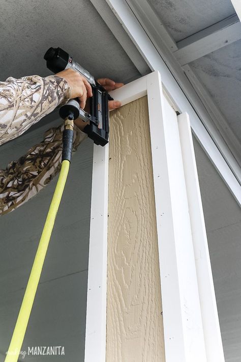 Nailing pre-primed trim pieces to porch posts for added curb appeal! Learn how to give your boring porch columns an easy DIY farmhouse makeover! #frontporch #porch #porchideas #DIY Front Porch Posts, Porch Pillars, Front Porch Columns, Farmhouse Makeover, Add Curb Appeal, Column Covers, Porch Remodel, Porch Columns, Porch Posts