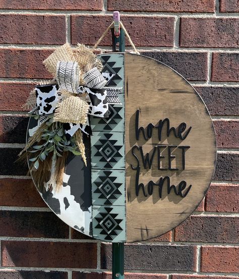 Western Aztec round door hanger.  Who doesn't love a cute western style?  This cute door hanger will welcome your guests and show off your western style.  SIZE:  This sign is an 18-inch wood round door hanger. Thickness is 1/2 inch. WOOD:  This door hanger is made from real birch wood. There may natural blemishes, wood grain and knots since it is real wood. This allows for the character of the wood to shine.  DESIGN:  This wood round is hand painted and stained  and may be distressed.  The wording and Aztec strip is laser cut wood about 3mm thick and adhered with wood glue and may have small nail brads to hold them. The final touches are a wired ribbon bow and greenery. (Ribbon may vary slightly, depending on availability) It comes ready to hang with a jute rope.  FINISHING TOUCH: This doo Gnome Front Door Sign, Checkered Door Hanger, Western Door Hangers, Western Wood Signs, Wood Porch Signs, Western Door, Hanging Quotes, Western Wreaths, Aztec Decor