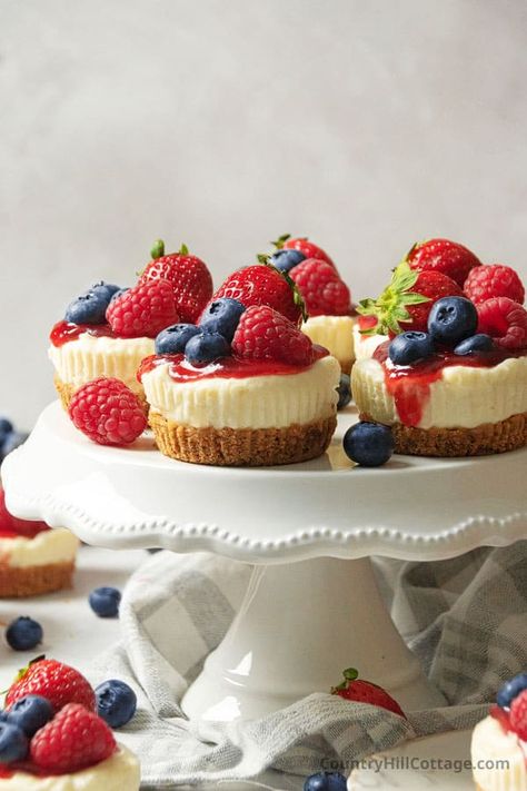 These delicious Philadelphia no bake mini cheesecakes are super simple to make. Smooth, creamy, and with a buttery graham cracker crust, they make a delightful bite-sized dessert that's perfect for any celebration and holiday. Using only a few basic ingredients and minimal equipment, these tiny cheesecakes are formed in a muffin pan and set up in the fridge instead of the oven. Serve them with fruit sauce, berries, whipped cream, caramel, chocolate, and cookies. | CountryHillCottage.com Cheesecake Individual Cups, Cheesecake With Berry Sauce, No Bake Mini Fruit Tarts, Cupcake Pan Cheesecakes, Strawberry Cheesecake Bites No Bake, Small Birthday Dessert Ideas, Mini Cheesecakes Strawberry, Mini Berry Cheesecakes, Mini Fruit Cheesecakes