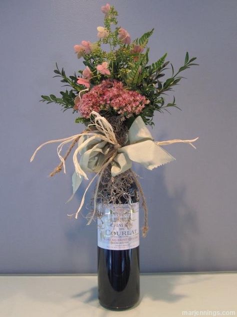 A nice bottle of wine is always a perfect gift for a host or hostess. We have all seen the velvet wine bags sold in stores these days - they're nice, but they lack individuality. Even worse are the plastic or foil bags that your liquor store will offer. Don't do it! A few years ago, I created a wine bouquet that can be wrapped around any bottle of wine, which I use when bringing wine as a gift. It takes a little time, but people do stop and notice this charming way of presenting a bottle of ... Wine With Flowers, Wine Gift Box Ideas, Wine Bottle Flowers, Bottle Gift Wrapping, Wrapped Wine Bottles, Bridal Shower Wine, Bottle Ideas, Bottle Diy, Wine Gift Boxes