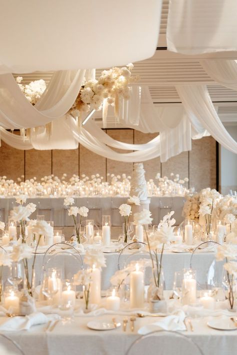 All white wedding. White Pillar Candles, white garden roses and orchids, and gold silverware. Off White Wedding Decorations, White Neutral Wedding Decor, White Cream Ivory Wedding, White And Candle Wedding, Minimal Center Piece Wedding, Wedding Table Glasses, Rose Gold White Wedding Decor, Off White Wedding Decor, Elegant Wedding Styling