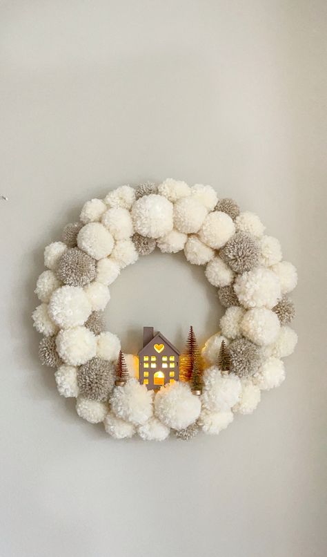 White and beige wool Pom Pom Christmas door wreath with light up house in the middle Diy Home Decor For Christmas, Christmas Wreath Diy Kids, Christmas Tree Ideas On The Wall, Homemade Christmas Trees Diy, Pompom Wreath Christmas Diy, Christmas Wreaths Craft, Bottle Brush Wreath Diy, Super Easy Christmas Crafts, Christmas Tree Diy Decor