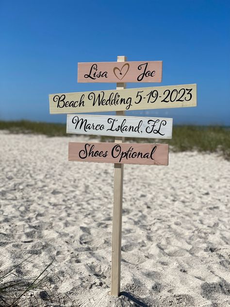 Personalized wedding directional sign for Beach wedding. Could be a perfect one of a kind gift for newlywed with couples names and destination wedding place, shoes optional and wedding date. custom writing by request.   The sign is made of high-quality wood, hand-painted with love and care in the Sunshine State with a rustic finish. You can choose any colors and your favorite destinations to write on your custom sign. The sign comes pre-drilled for easy and fast assembly, and a self-stand option Small Wedding Beach Ideas, Wedding Aisle Decorations Beach, Boho Wedding Beach Decoration, Beach Wedding Signs Cute Ideas, Wedding Beach Ideas Decoration, Diy Beach Wedding Decor, August Beach Wedding Colors, Beach Elopement Decor, Micro Wedding Ideas Beach