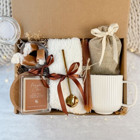 Introducing our Hygge Fall Gift Box, the perfect blend of comfort and sophistication! The gift box included: - White fluffy socks - White ceramic ribbed mug - Pumpkin wax melt - Jar of sea salt caramels - Beverage of your choice (tea/coffee/hot chocolate) - Golden tea spoon - Honey sticks - Coaster Coffee And Chocolate Gift Basket, Hygge Gift Basket Ideas, Coffee Gift Basket Ideas Diy, Care Package Aesthetic, Small House Warming Gift, Recovery Gift Basket, Fall Gift Basket Ideas, Pioneer Meeting, Coffee Present