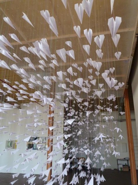 1,000 Paper Airplanes Trying to Escape Paper Art Installation, Paper Aeroplane, Textiles Sketchbook, Paper Installation, Window Display Design, Airplane Art, Paper Airplane, Diy Paper Crafts Decoration, Kinetic Sculpture