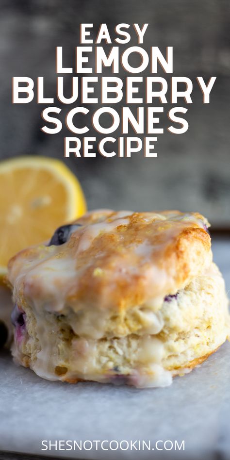 An image of a Lemon Blueberry Scone, drizzled with a light glaze resting on a grey marble board. A sliced lemon sits in the background as garnish. The purpose of this image is to show the completed recipe. Blueberry And Lemon Scones, What To Bake With Buttermilk, Scones Made With Buttermilk, Lemon Blueberry Scones Recipe Easy, Lemon And Blueberry Scones, Blueberry Scones With Buttermilk, Healthy Scones Recipe Greek Yogurt, Awrey Bakery Recipes, Blueberry Scone Recipes