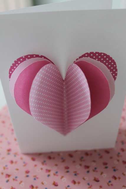 a white box with pink heart shaped paper on it's lid sitting on a polka dot table cloth